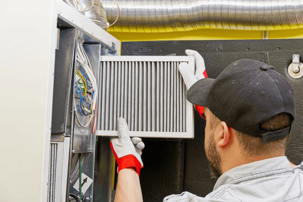 HVAC technician replacing furnace filter in Livonia MI